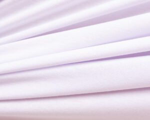 Rolo de tecido de microfibra Ramatex na cor branca, com toque suave e acabamento fosco, ideal para a fabricação de lingerie, moda íntima e peças confortáveis.