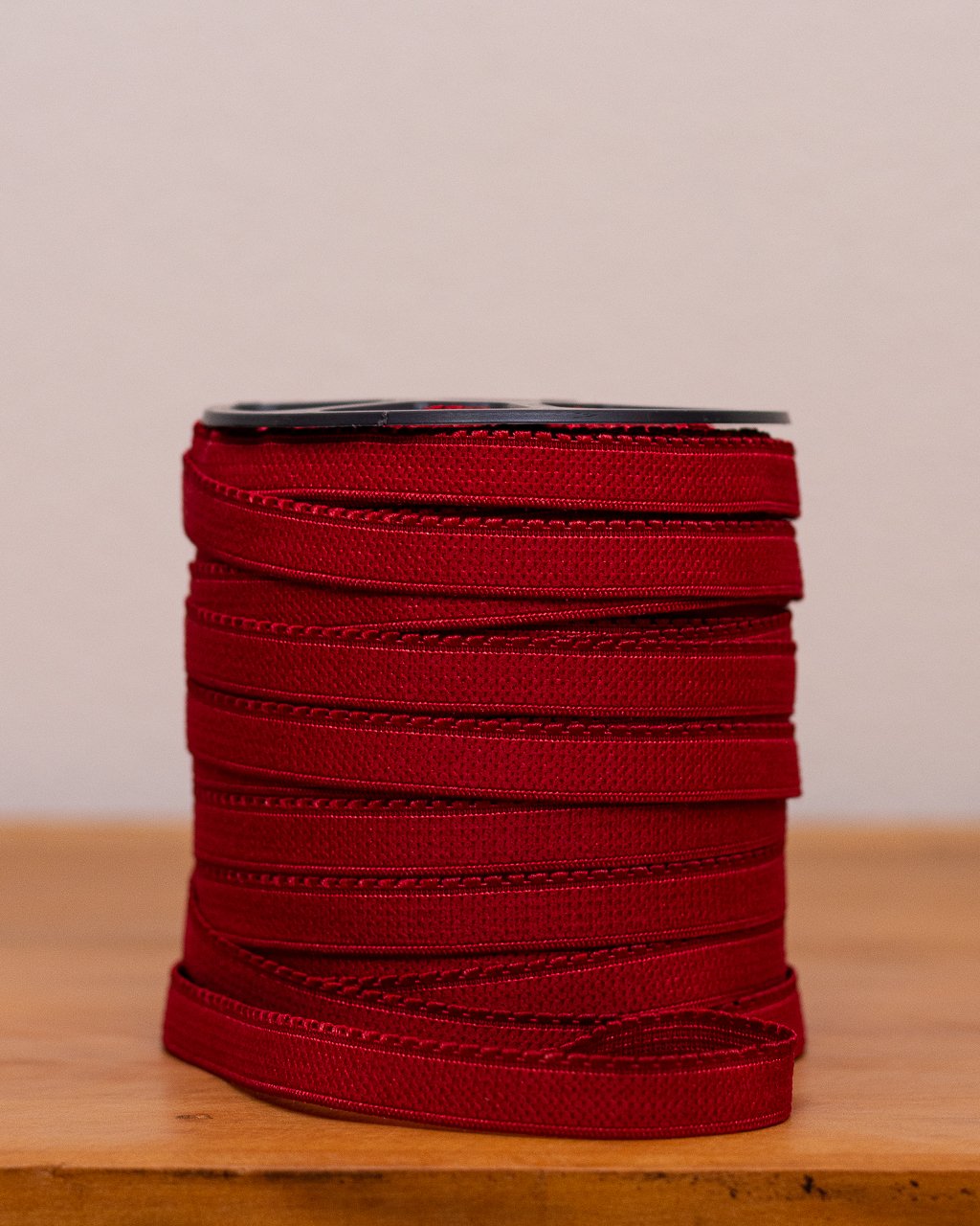 Rolo de elástico de bico na cor rubi, com trama decorativa, para confecção de lingerie, Evelin Tecidos