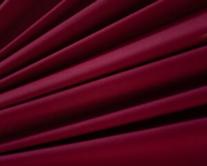 Rolo de tecido de malha 24.1 100% algodão na cor Sensuale (vinho ou bordô profundo), com textura macia e uniforme, ideal para a fabricação de lingerie.