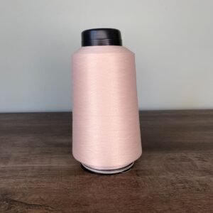 Carretel de 300g de fio Helanstar na cor base (bege claro ou nude), ideal para costura de lingerie e moda íntima.