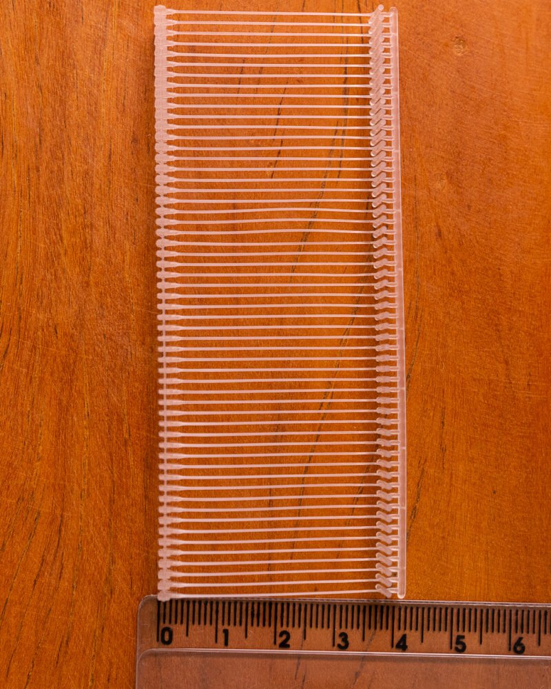 Pino de tag transparente para fixação de etiquetas em roupas e tecidos.