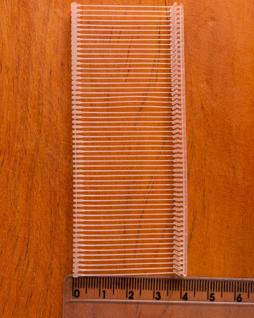 Pino de tag transparente para fixação de etiquetas em roupas e tecidos.