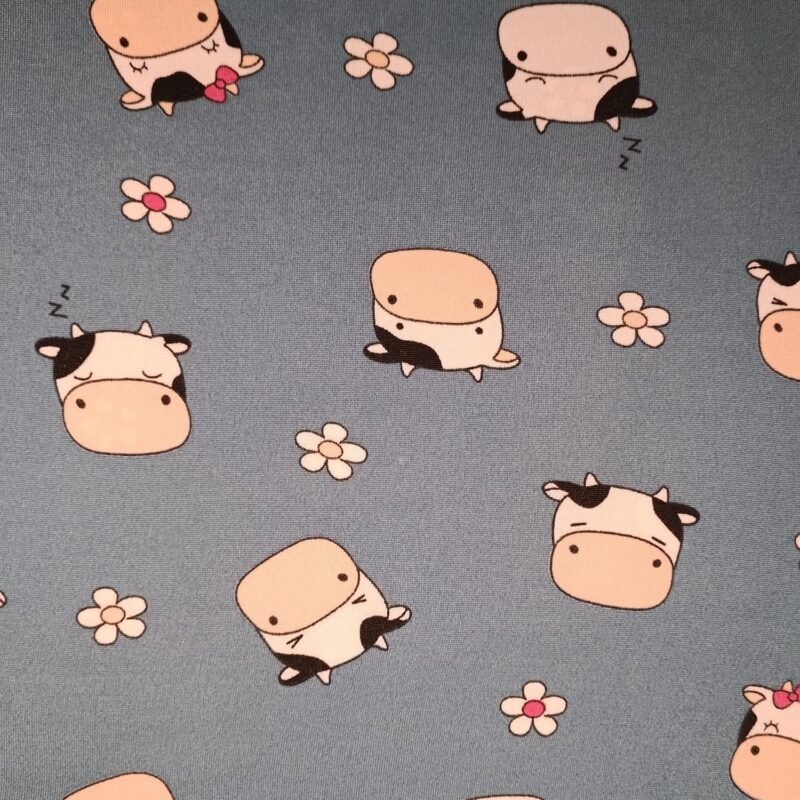 Tecido Suede ST10 com vacas estilo cartoon e flores brancas, ideal para lingerie criativa e divertida.