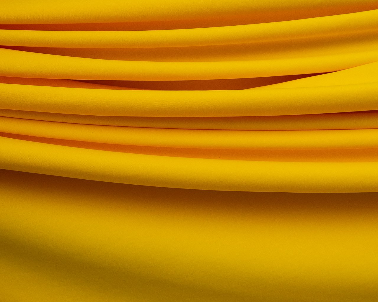 Rolo de tecido Cotton 30.1 Penteado liso na vibrante cor Camaro (amarelo ou laranja intenso), ideal para a confecção de lingerie e moda íntima. Produto da Evelin Tecidos.