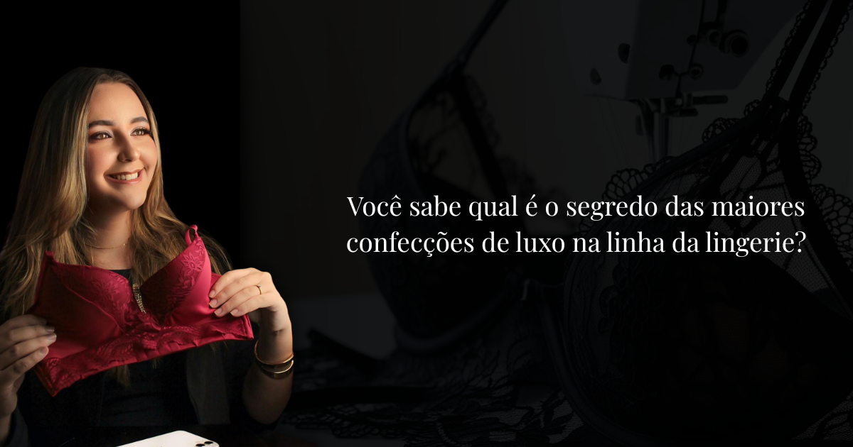 Mulher sorridente segurando lingerie vermelha com fundo escuro e máquina de costura ao fundo, representando confecção de lingerie de luxo.