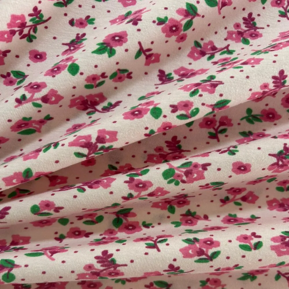 Tecido Cotton Estampado Floral Pink Fundo Soft. Estampa de buquês de flores pink e verde sobre fundo rosa suave, 96% Algodão, para pijamas e moda íntima.