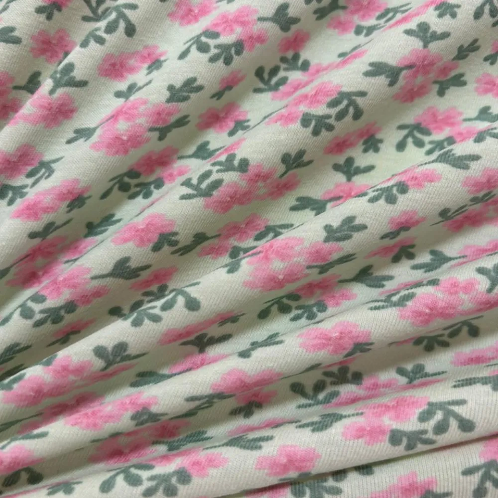 Tecido Cotton Estampado Floral Pink e Chumbo. Estampa de buquês de flores pink com folhas cinza chumbo sobre fundo claro, 96% Algodão, para pijamas e moda íntima.