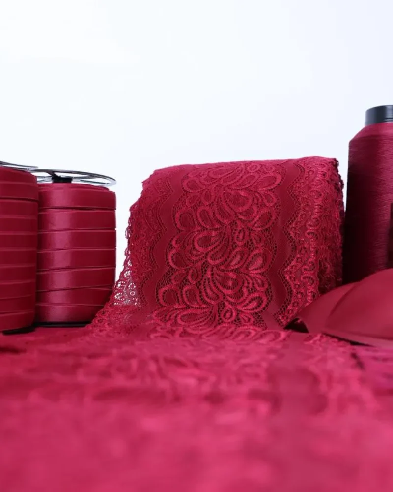 Kit de fabricação de lingerie na cor Carmim com tecidos, elásticos, aviamentos, linhas e bojos organizados para produção de até 50 conjuntos.
